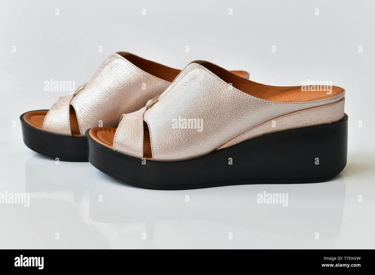 Schöne weibliche Clogs auf weißem Hintergrund Stockfoto