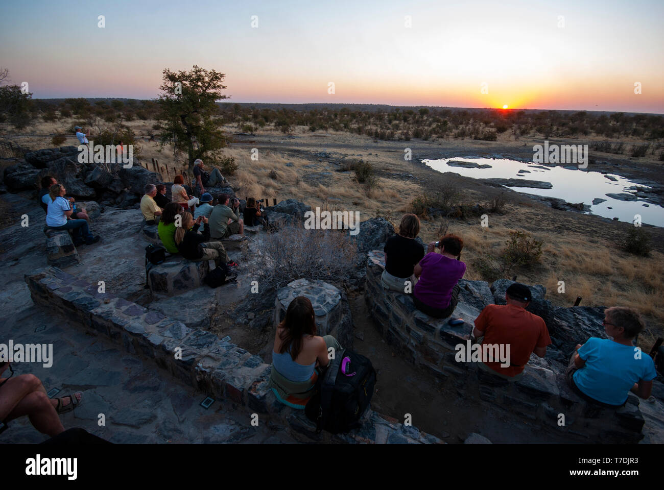 Touristen den Sonnenuntergang am Moringa Waterhole, Halali Resort, Etosha National Park, Namibia Stockfoto