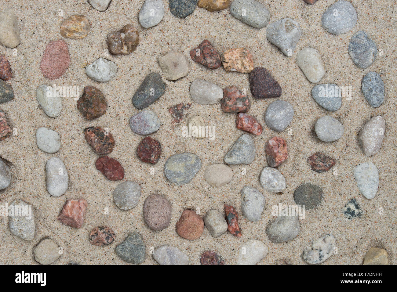 Spiralförmige Muster aus pebbes auf Sand Hintergrund Stockfoto