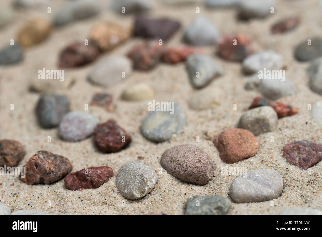 Spiralförmige Muster aus pebbes auf Sand Hintergrund Stockfoto