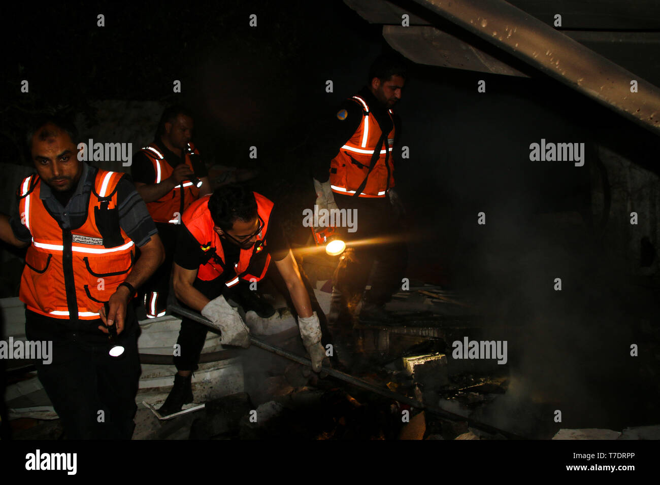 Mai 5, 2019 - Beit Lahija, Gaza, Palästina, 05. Mai 2019. Die Mitglieder der zivilen Verteidigung in Gaza zu einem Brand in einem Gebäude in der Stadt Köder Lahija, war eine Familie zu Hause und wurde gezielt und von israelischen Jets zerstört erlöschen. Das Gebäude, das in der Nähe der amerikanischen Schule in Beit Lahija entfernt war, im nördlichen Gazastreifen, getroffen wurde während eines intensiven israelische Luftangriffe im Gazastreifen am Samstag und Sonntag, die als Reaktion auf den Abschuss von Dutzenden von Raketen über die Grenze aus dem Gazastreifen begann, in den Süden Israels (Credit Bild: © Ahmad Hasaballah/IMAGESLIVE über ZUMA Draht) Stockfoto