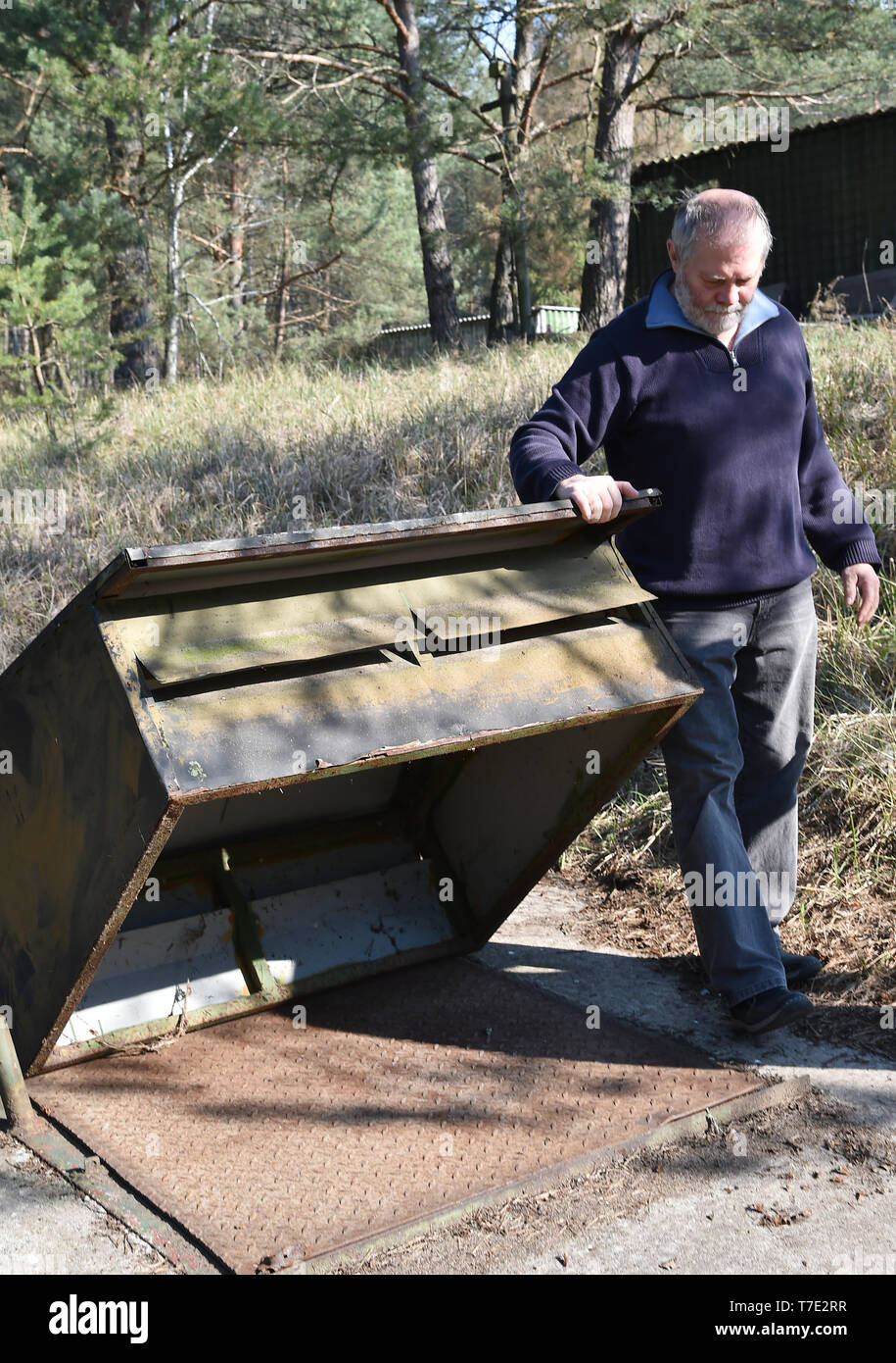 06.04.2019, Brandenburg, protzel Ot Harnekop: Wolfgang Schornig, Berlin Verein für Speicher und die Erhaltung der zeitgenössischen Geschichte eV, eröffnet den Zugang zu einer Welle mit einem Notausgang des nuklearen Bunker Harnekop. Auf drei Etagen 30 Meter unter der Erde, der DDR-Verteidigungsminister wollte sich mit seinem Obersten Befehlshaber im Falle eines Krieges zu verankern. Der derzeitige Eigentümer hat die Website und die Bunker zu verschiedenen Mietern, die im Streit um die Nutzungsrechte vergeben. Foto: Bernd Settnik/dpa-Zentralbild/ZB | Verwendung weltweit Stockfoto