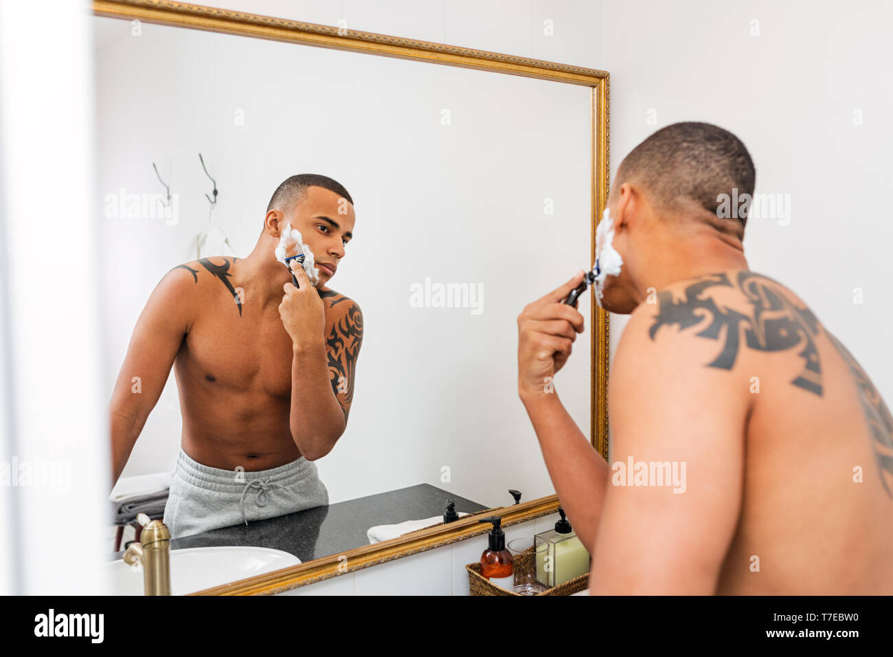 Mann, der vor einem Spiegel rasieren nach einer Dusche Stockfoto