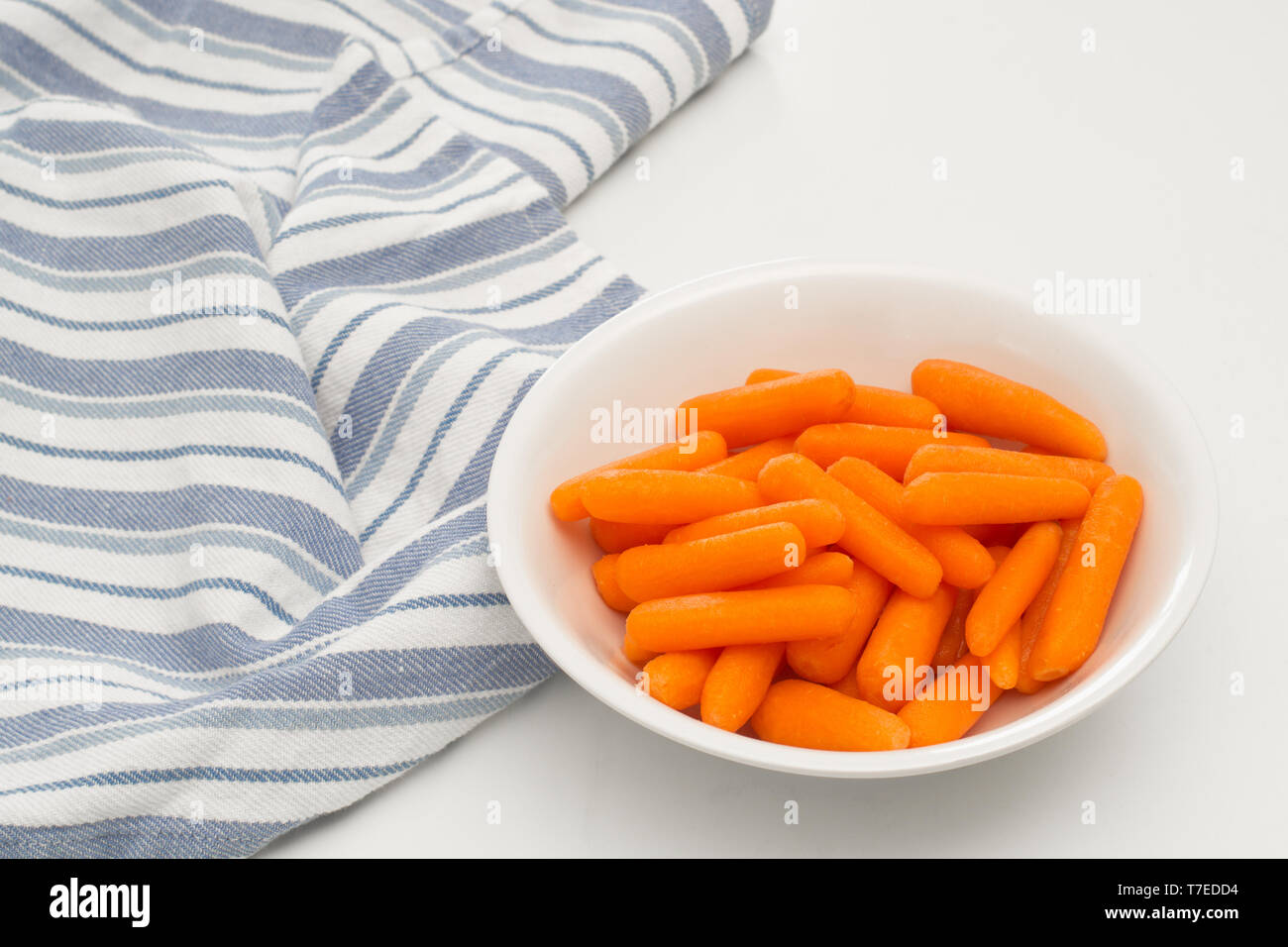 Karotten in Teller auf Weiß. Stockfoto