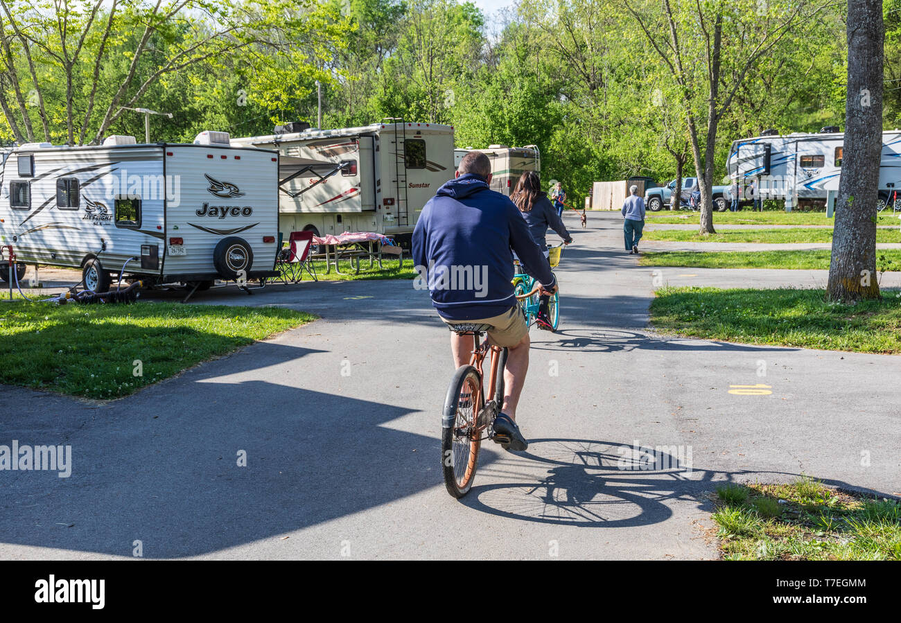 Kalkstein, TN, USA -4/26/19: ein Mann und eine Frau Reiten Fahrräder durch ein RV Park an einem sonnigen Frühlingstag. Stockfoto