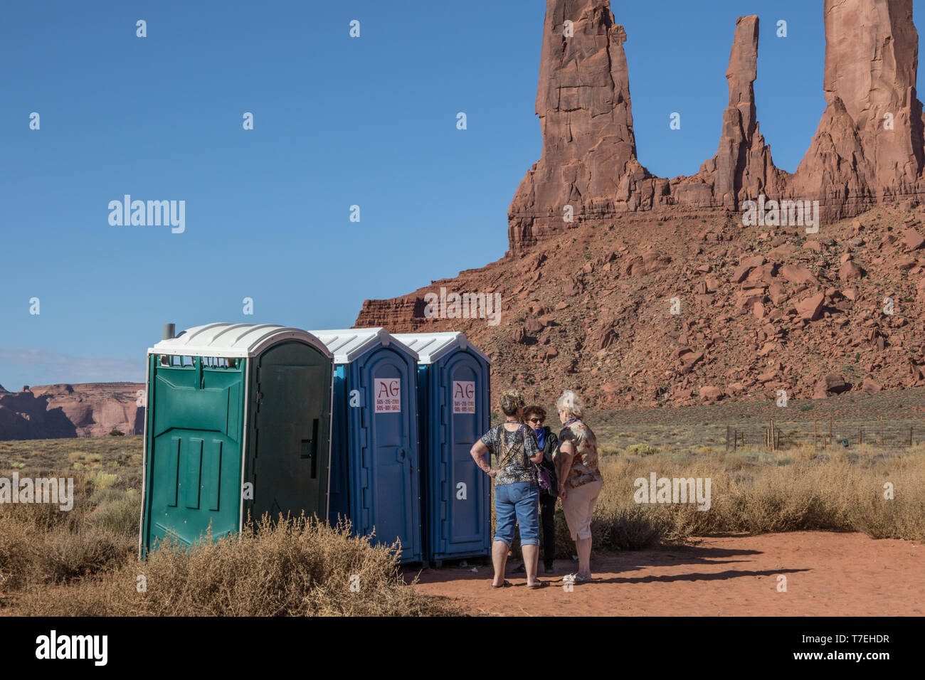MONUMENT Valley, in der Nähe von KAYENTA, AZ, USA -10/2/15: Drei Frauen stehen Reden während der Wartezeit für den Zugang zu mobilen Toiletten im Monument Valley. Stockfoto