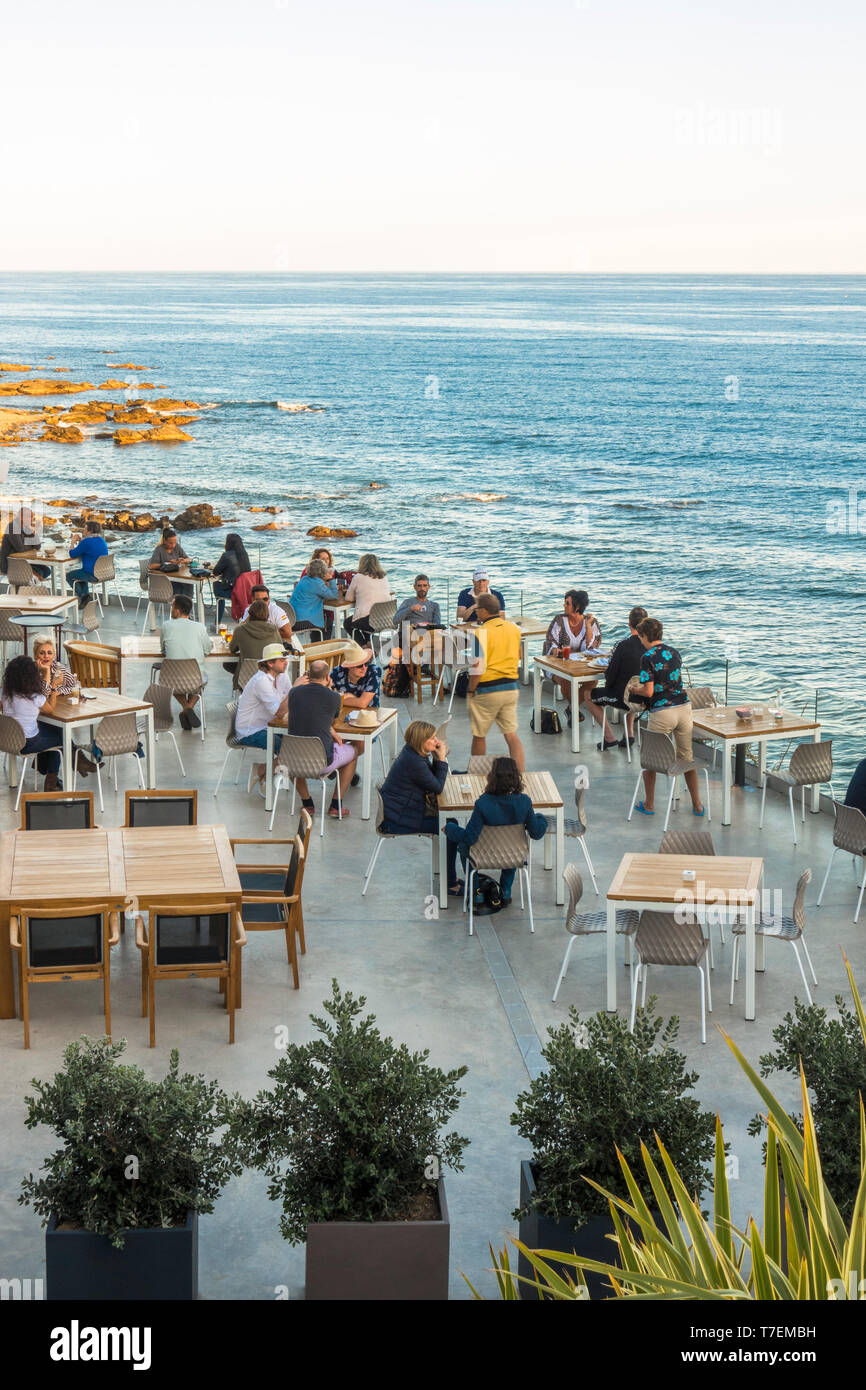 Die Menschen genießen den Nachmittag auf einer Terrasse am Meer mit Blick auf das Mittelmeer, Benalmadena, Andalusien, Spanien. Stockfoto