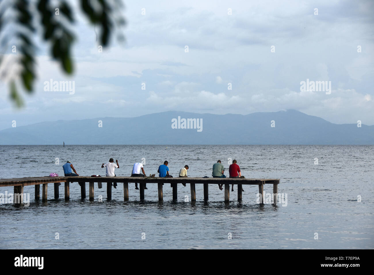 Ansicht der Rückseite des Menschen sitzen auf Jetty genießt die Aussicht Stockfoto
