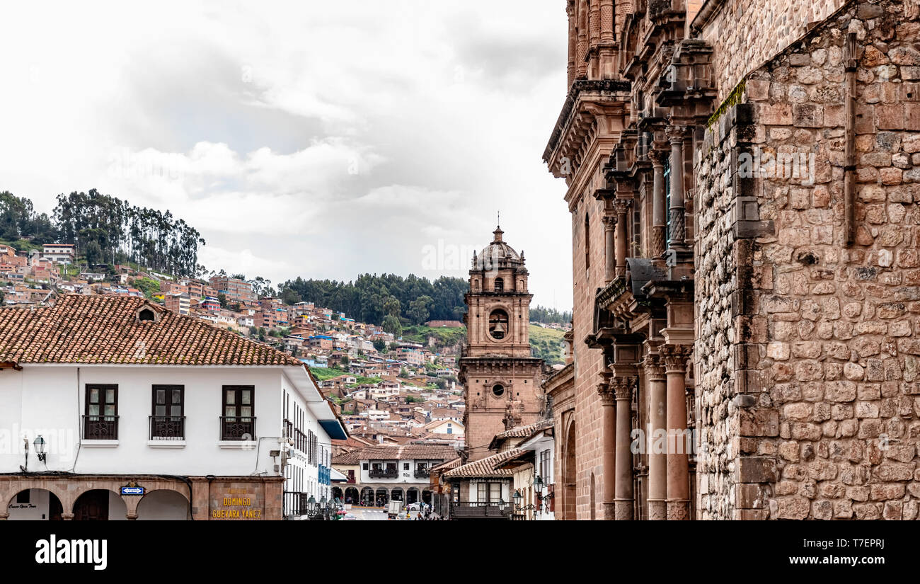 Seitenansicht von der Straße bis zur Plaza de Armas mit der die Kirche und das Kloster Unserer Lieben Frau von der Barmherzigkeit, die Iglesia de la Merced und die Hügel rund um Cusco in Pro Stockfoto