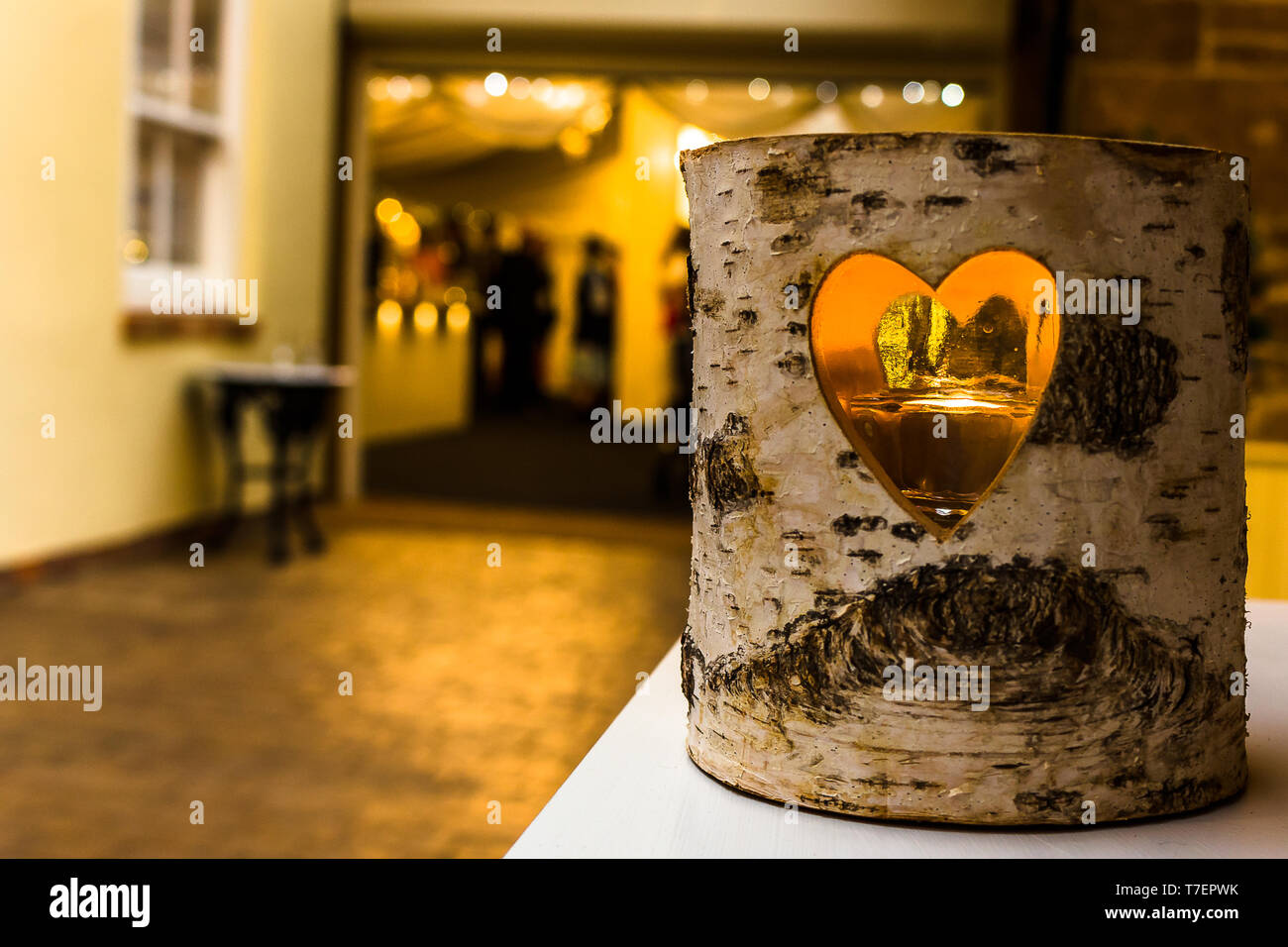 Kerze hinter dem Fenster in der Mitte eines Archivs mit Menschen an der Bar im Hintergrund. Stockfoto