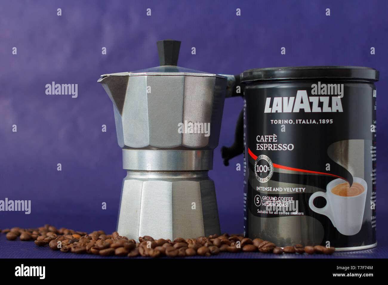 TURIN, Italien - 2. Mai 2019: Lavazza Kaffee Glas auf dem violetten Hintergrund. Moka Topf und Lavazza Kaffee Paket, TURIN, ITALIEN. Eine erläuternde Editorial Ich Stockfoto