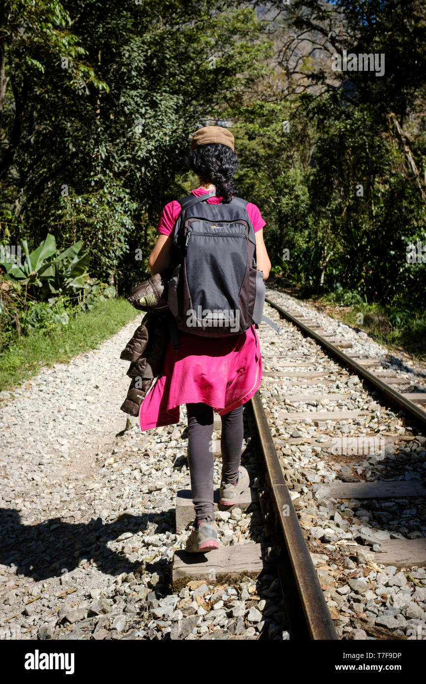 Junge Frau mit ihrem Rucksack zu Fuß auf der railtrack nach Aguas Calientes und Machu Picchu, Peru Stockfoto