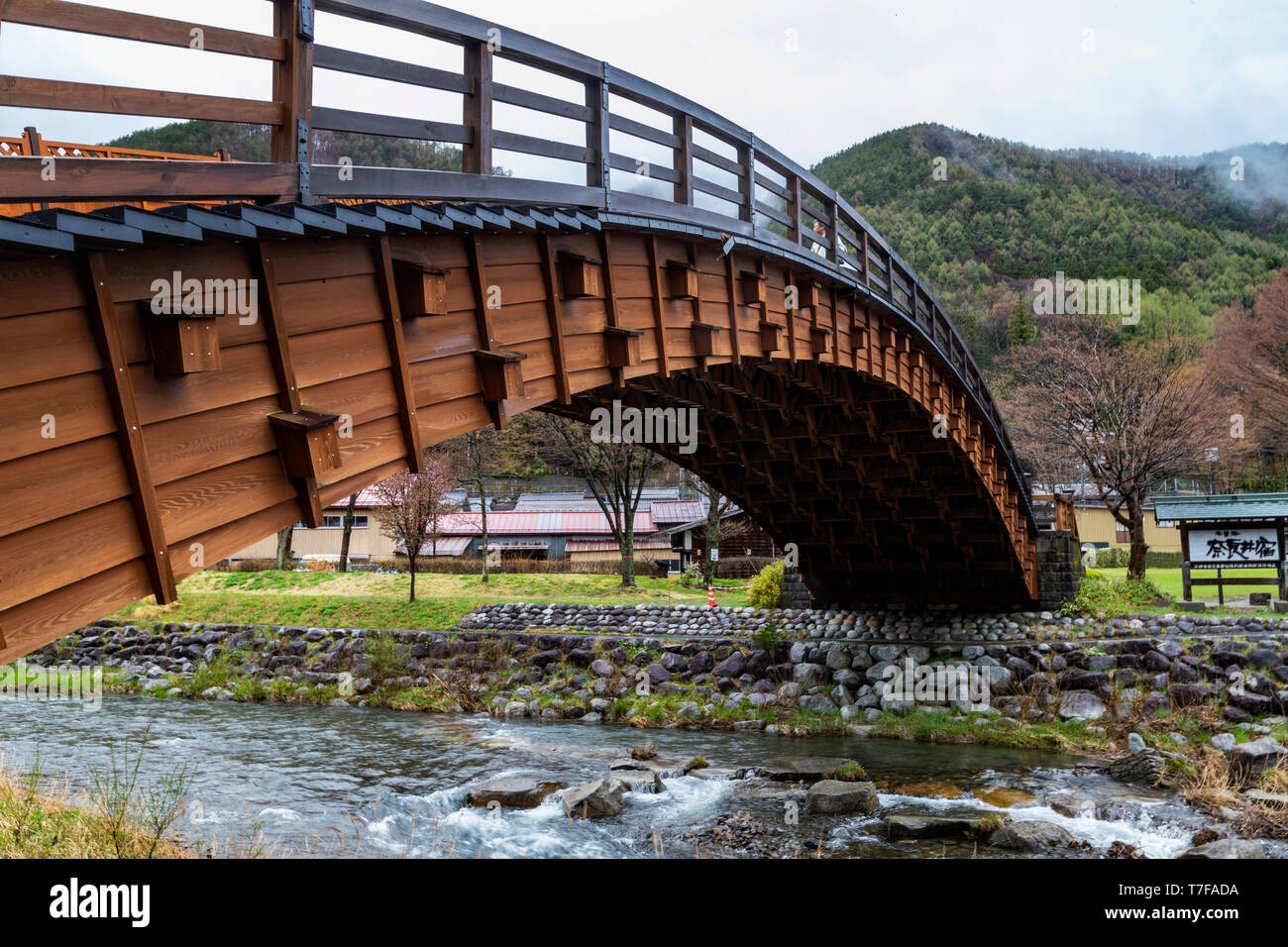 Diese Brücke überquert den Fluss Narai, die parallel zur Hauptstraße verläuft. Verlängerung 30 m ist sie eine der längsten geschwungenen Holzbrücken in Ja Stockfoto