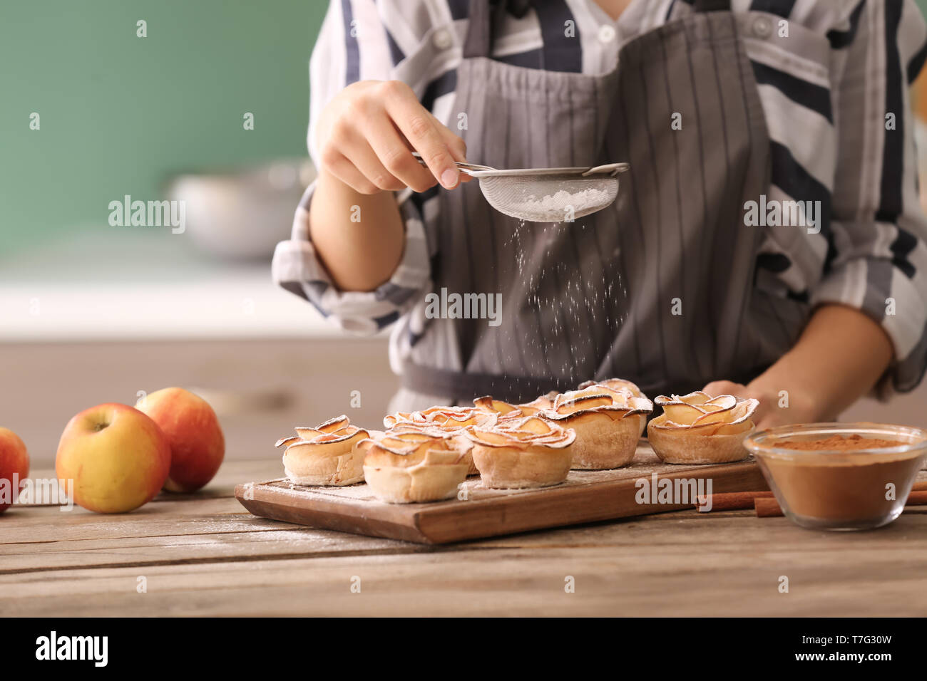 Frau macht Apple Rosen aus Blätterteig in der Küche Stockfoto