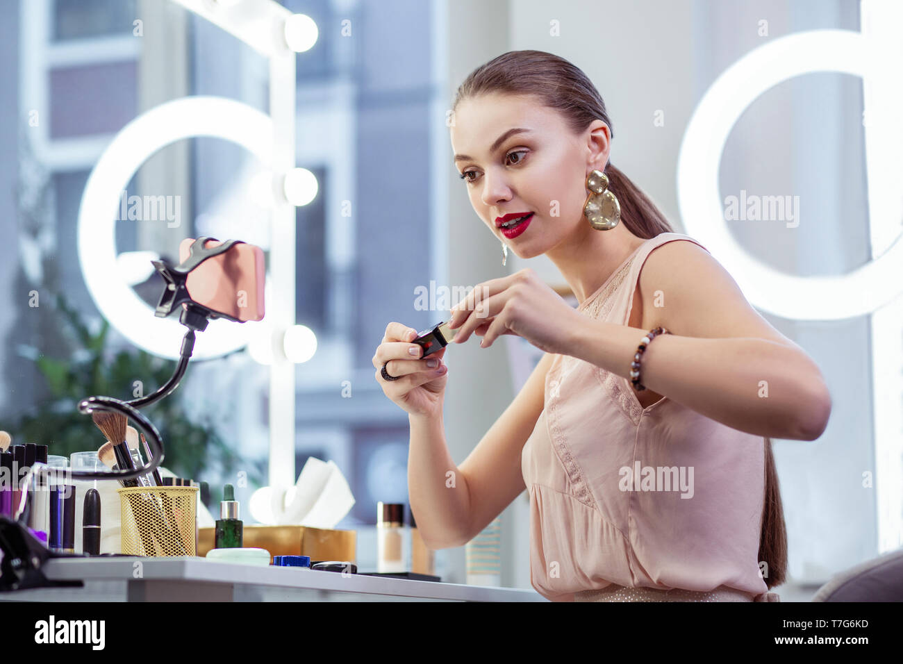 Hübsche junge Frau Testen von Kosmetika, die an Kamera Stockfoto