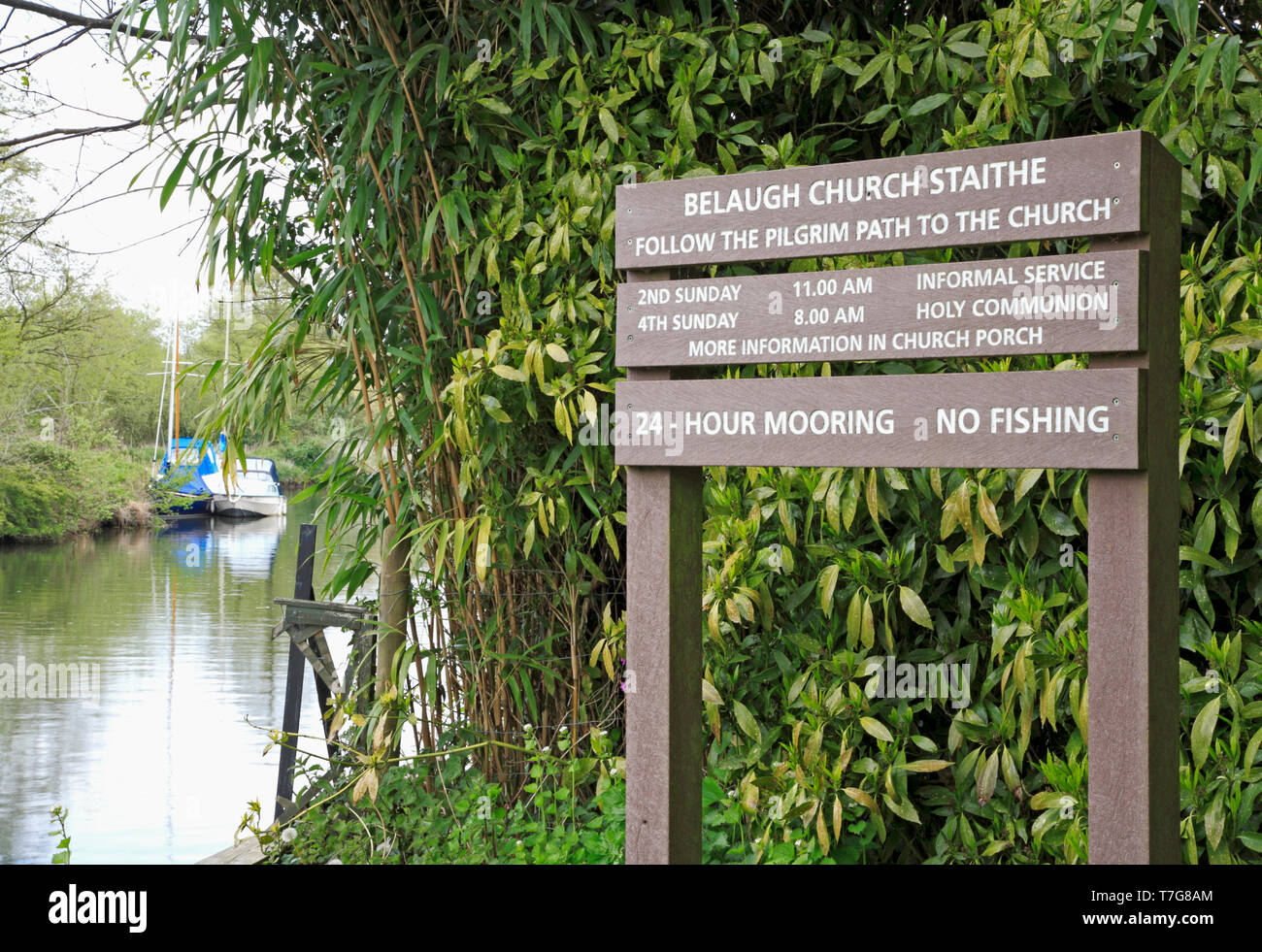 Ein Hinweisschild an der Kirche Staithe am Ufer des Flusses Bure mit Service Zeiten für die Kirche des Hl. Petrus an Belaugh, Norfolk, England, UK, Europa. Stockfoto