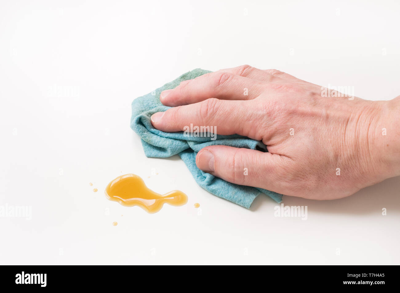 Abwischen der Hände verschüttete Kaffee mit Putzlappen. Stockfoto