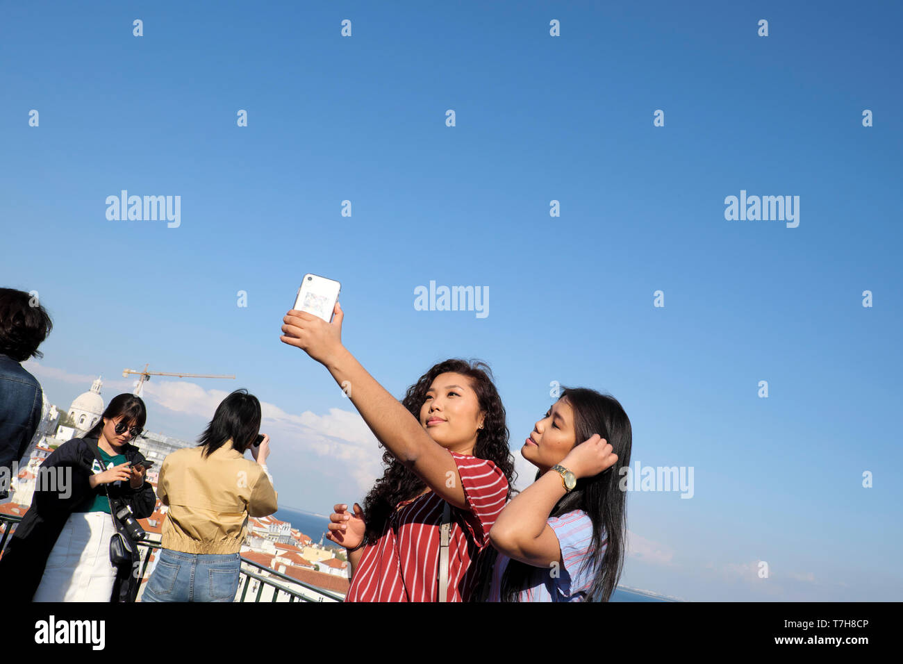 Schöne junge Frau mit Freund unter selfie mit Handy mit Hintergrund der Alfama von Lissabon in Portugal Europa EU-KATHY DEWITT Stockfoto