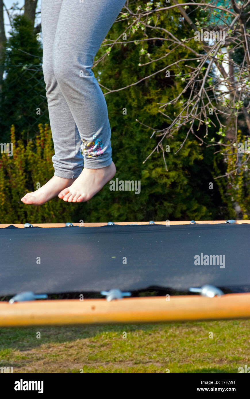 Gefrorene Bewegung über dem Trampolin, springen auf dem Trampolin im Garten Stockfoto