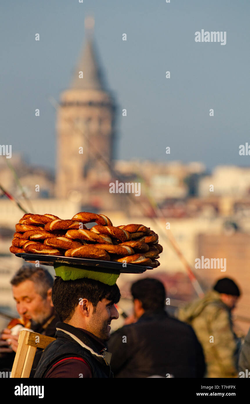 Ein türkischer Mann trägt Simit auf einem Tablett auf dem Kopf auf den Galataturm, Istanbul, Türkei Stockfoto
