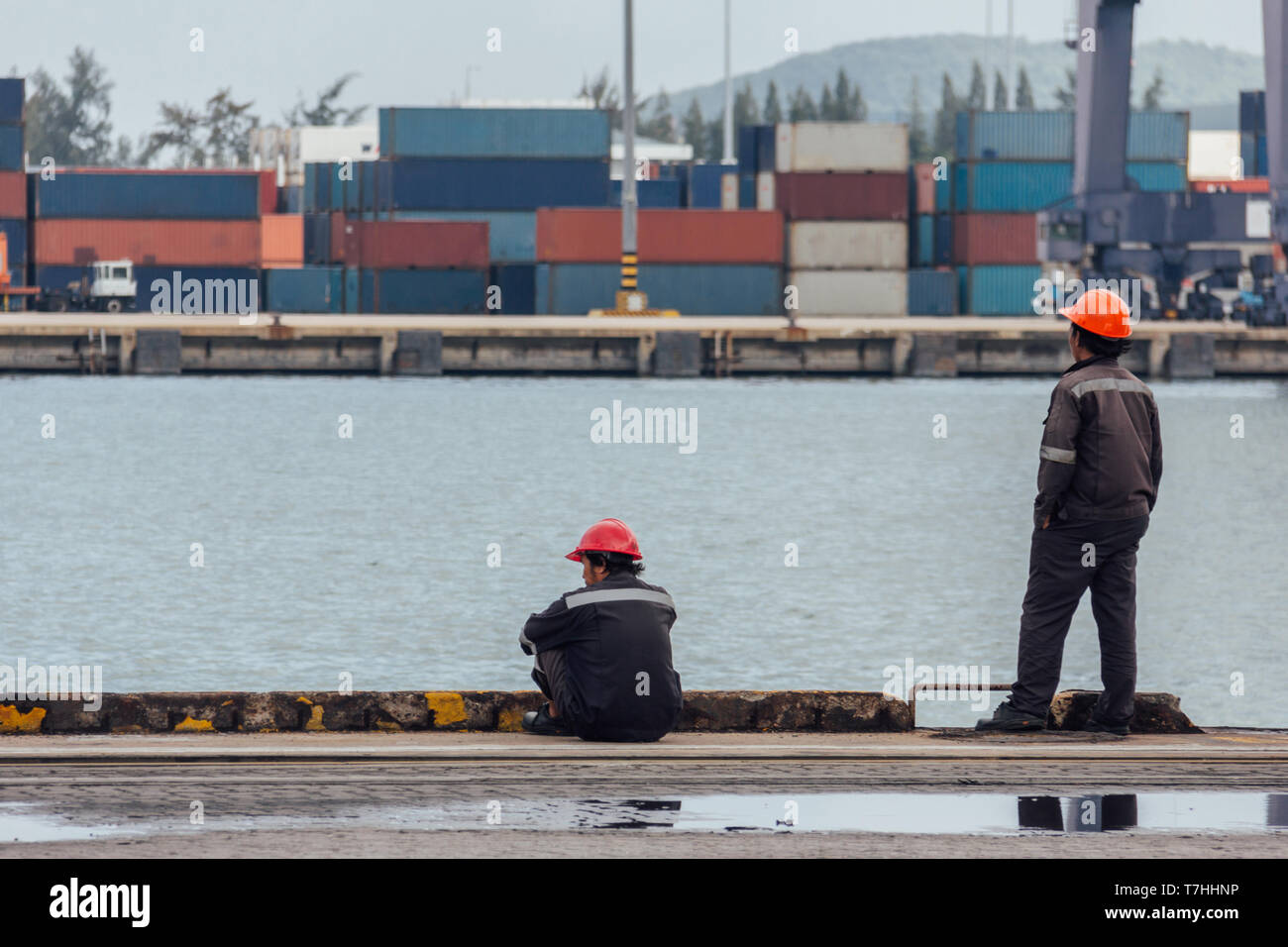Hafenarbeiter auf dem Boden nach Abschluss der Arbeiten am Terminal Port. Leute lifestyle Konzept. vintage Foto und Film Stil. Stockfoto