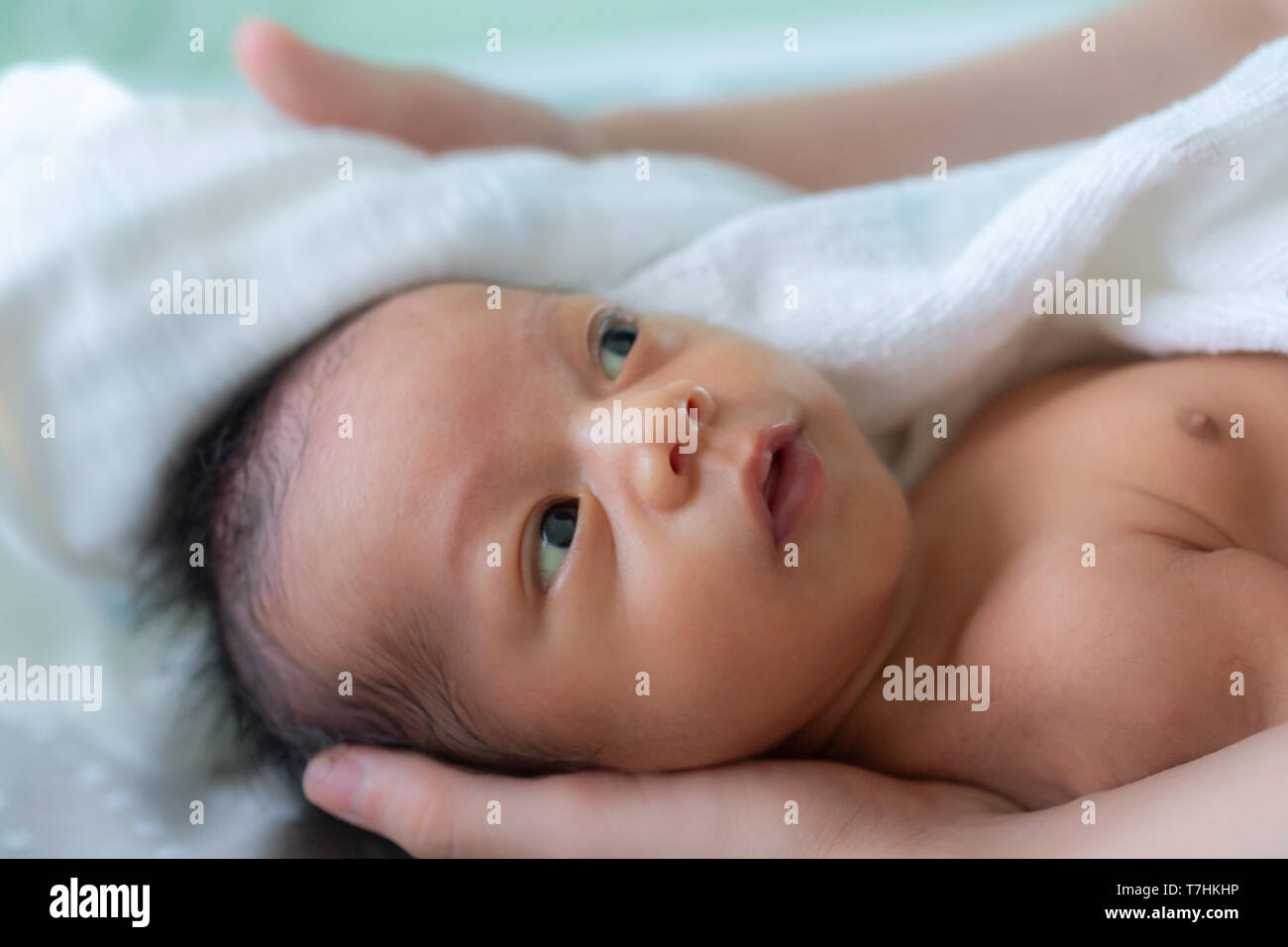 Asiatische baby Junge lächelnd und Gefühl glücklich nach der Badewanne. Mutter Trocknet und reibt ihr neugeborenes Baby Haare und den Kopf mit einem Handtuch nach einer Dusche. f Stockfoto