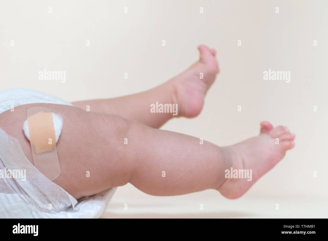Baby Junge Beine mit einem band-aid Patch nach der Einnahme ein Impfstoff. Arzt oder Krankenschwester, Pflaster auf Baby Bein im Krankenhaus. Stockfoto