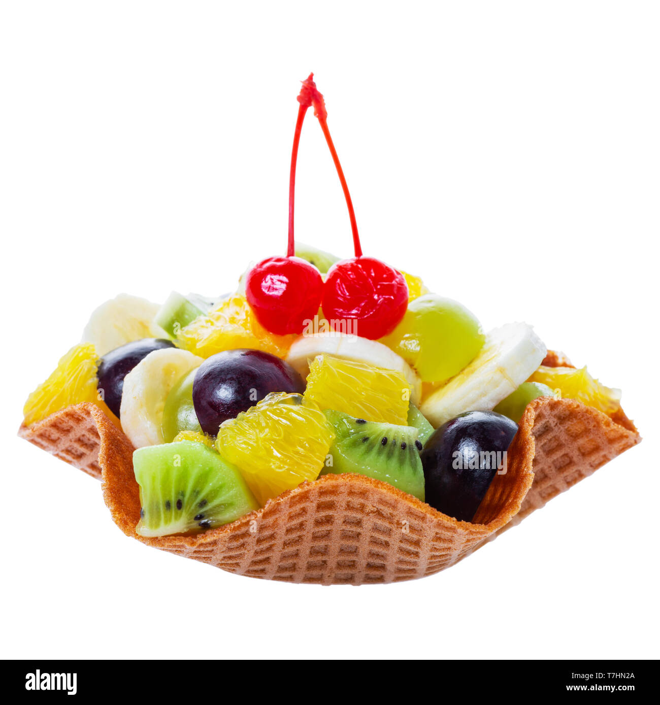 Frisch geschnittene Früchte im Waffle Kegel bowl dekoriert maraschino Kirsche auf auf weißem Hintergrund isoliert ist. Stockfoto