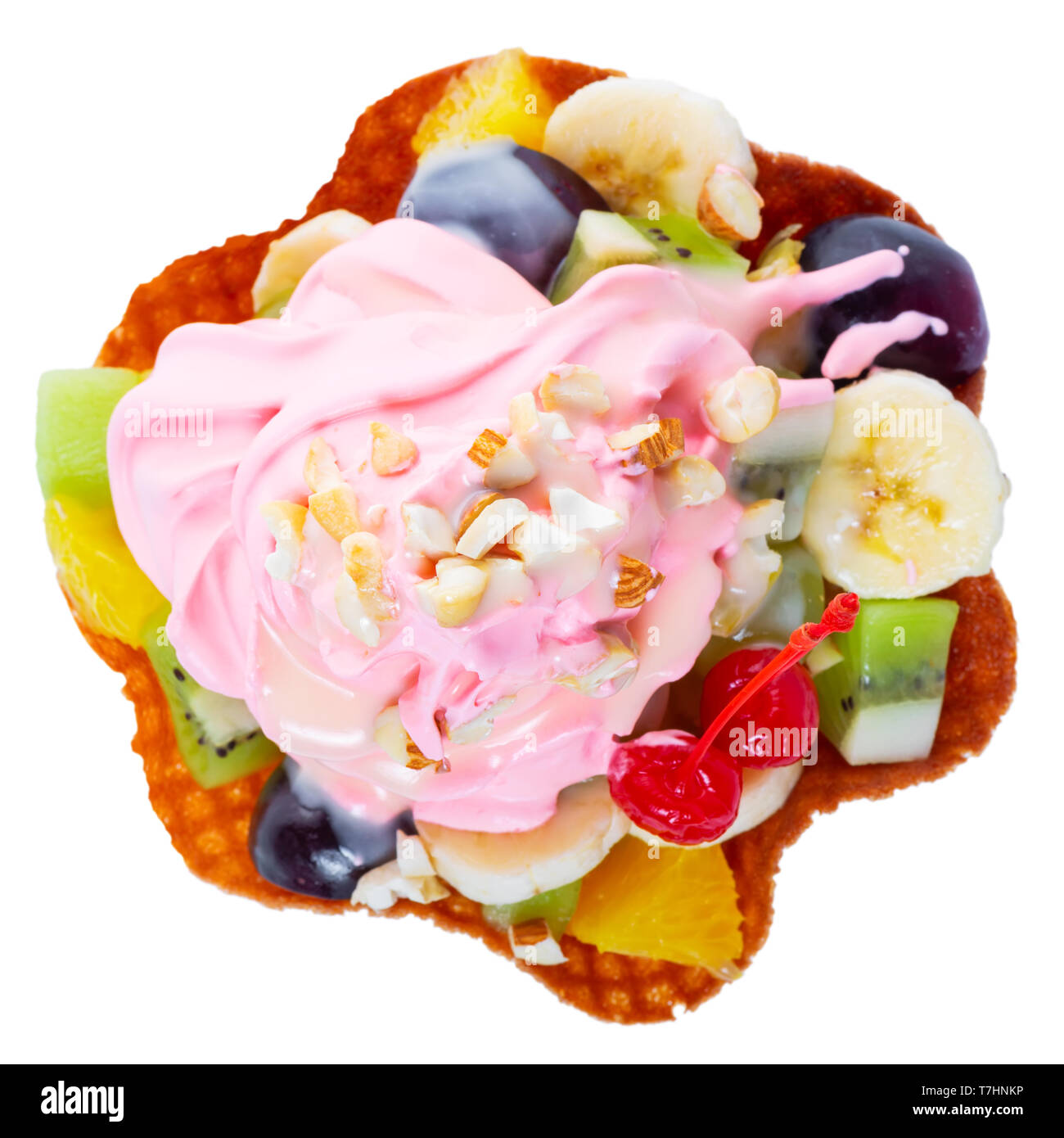 Blick von oben auf die gewürfelten Früchten im Waffle rosa Kegel Schüssel mit Sahne und Nüssen dekoriert maraschino Kirsche ist auf weißem Hintergrund Stockfoto