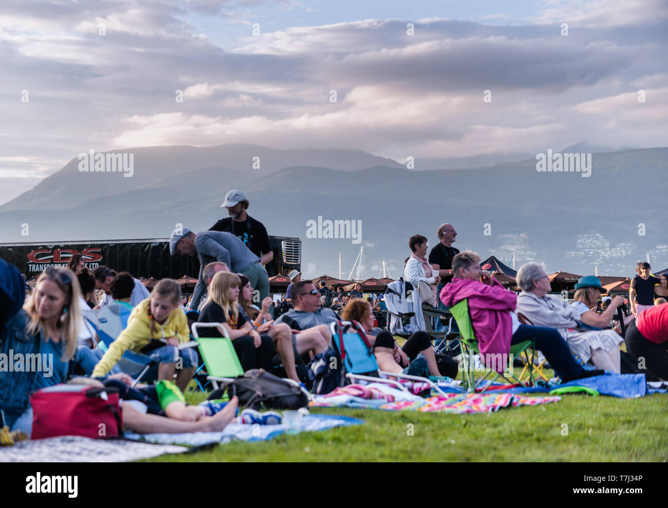 Publikum genießen Sie die dramatische outdoor Einstellung der Vancouver Folk Festival, mit Berge und Wolken im Hintergrund an einem sommerlichen Abend Stockfoto