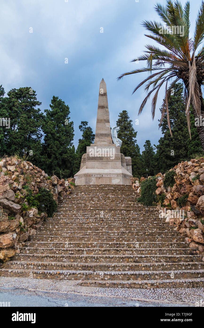 Die steinernen Treppen und der Obelisk mit Skulptur der Engel auf dem Montjuic Friedhof in bewölkten Tag, Barcelona, Katalonien, Spanien Stockfoto