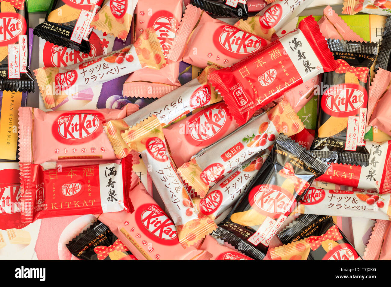 Verstreute Auswahl an japanischen Mini-Kitkat-Bars, einschließlich Aromen wie Himbeere, Banane, Nuss, Pfirsich und Traube. Draufsicht. Stockfoto