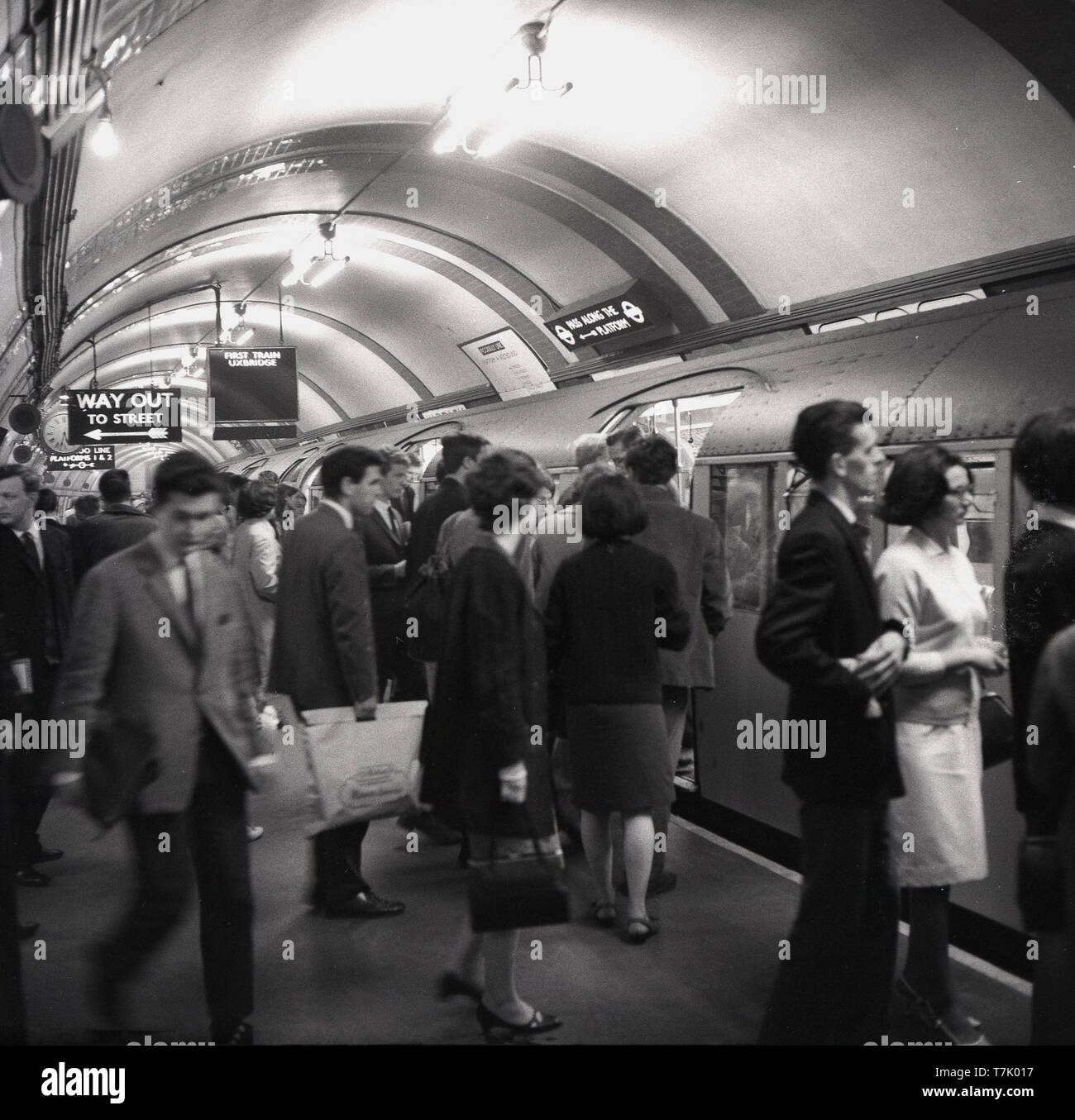 1960, historische, in der Londoner U-Bahn, Bild zeigt die Piccadilly U-Bahn auf einer Plattform an einer Station, an der belebten Plattform Menschen sind in den Zug einsteigen, die in Uxbridge ist .... 1906 eröffnet, die Piccadilly Linie verläuft von Norden Londons, nordwestlich von London. Stockfoto
