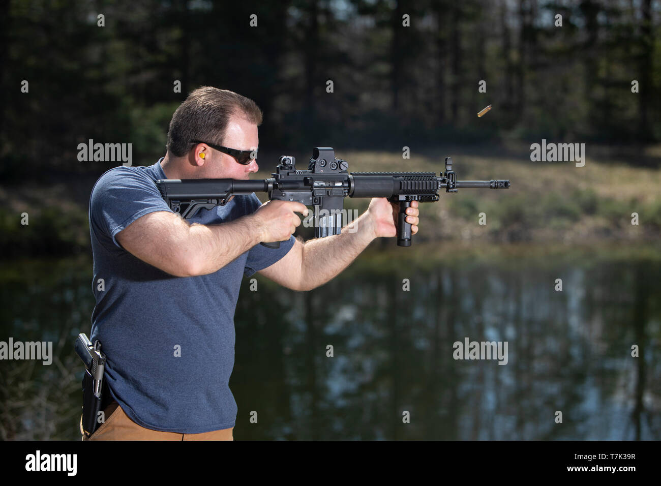 Ein Mann Schießen mit einem Sturmgewehr und die ausgeworfene Shell in der Luft. Stockfoto