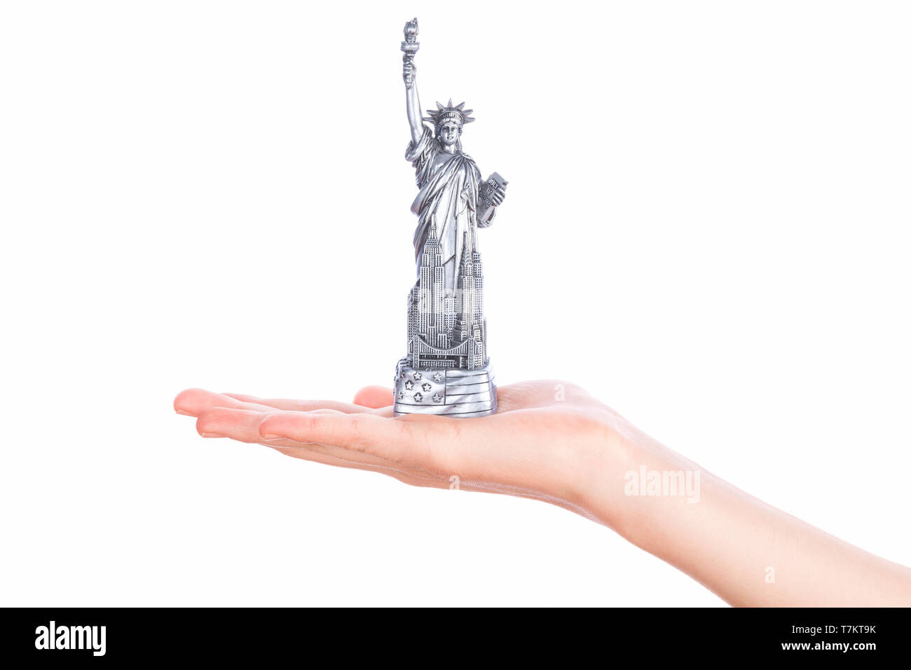 Hand, die Statue of Liberty Souvenir Spielzeug auf weißem Hintergrund. Metall-Dekoration. Stockfoto