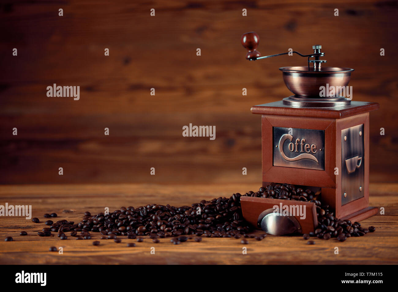 Kaffeemühle mit Kaffeebohnen auf hölzernen Hintergrund Stockfoto