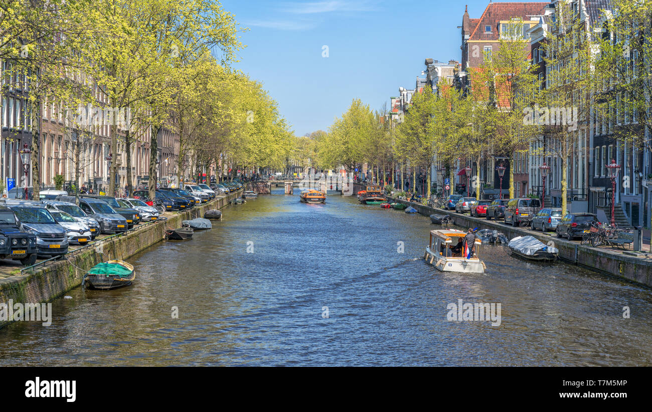 Amsterdam, Niederlande - 09 April, 2019: Klassische Fahrräder und historische Häuser in der Altstadt von Amsterdam. Typische Straße in Amsterdam mit Canal und bunten Stockfoto