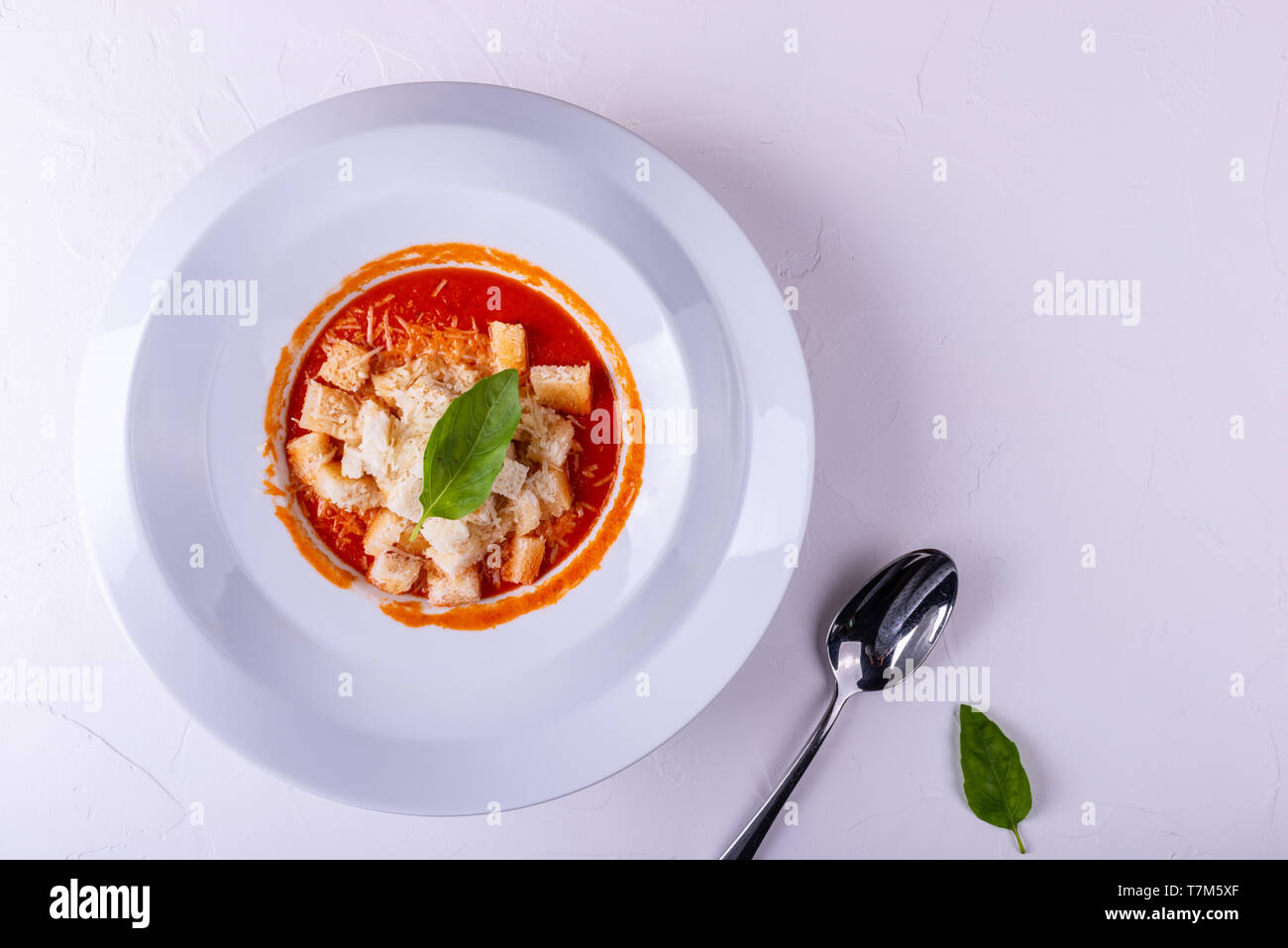 Tomaten Cremesuppe mit Crackern in eine weiße Platte auf einem weißen Hintergrund. Stockfoto