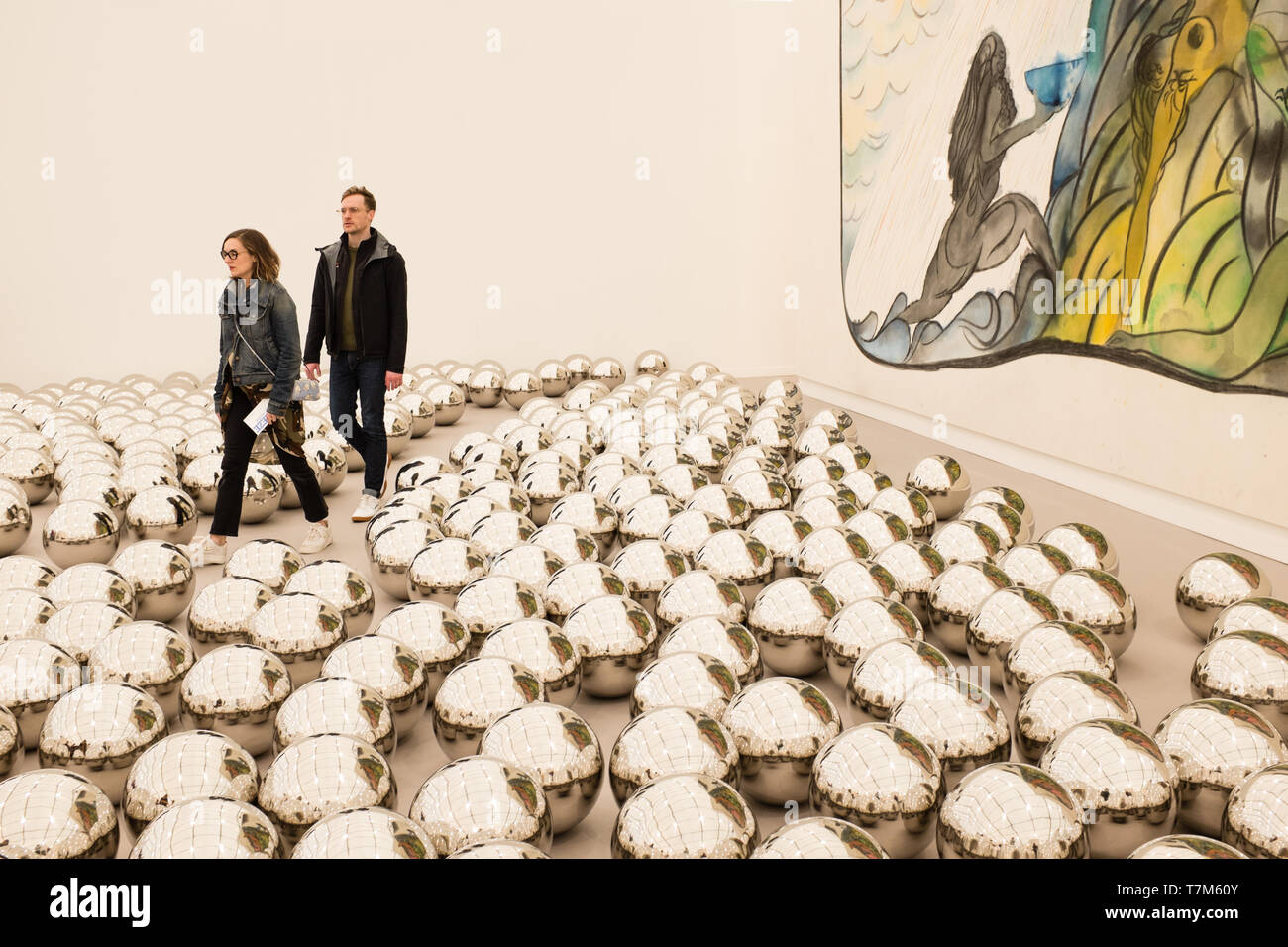 New York, NY-Mai 3, 2019. Zuschauer wandern durch Yayoi Kusame's "narziss Garten' voll aus Edelstahl Kugeln, vor Chris Olifi's Öl" zu nehmen und zu geben" in der Victoria Miro Gallery auf der Frieze Art Fair in New York City's Randalls Island. Stockfoto