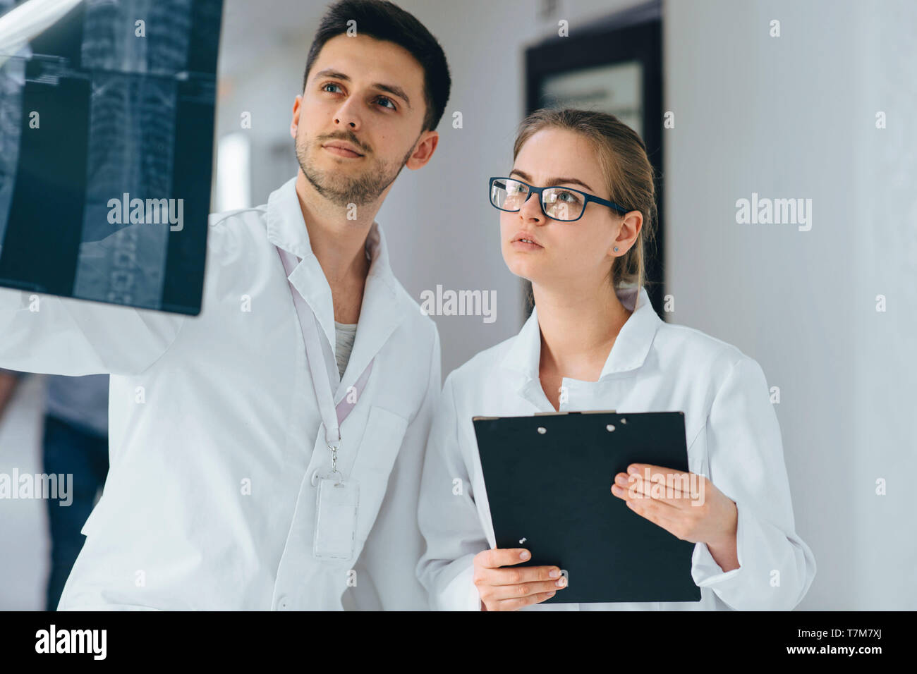 Zwei Ärzte, die Röntgenstrahlen Bilder wirbelsäule an der Klinik Stockfoto