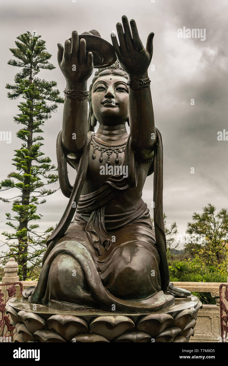 Hong Kong, China - 7. März 2019: Insel Lantau. Closeup, einer der sechs Devas bietet Obst zum Tian Tan Buddha. Bronzestatue von vorne mit Gre gesehen Stockfoto