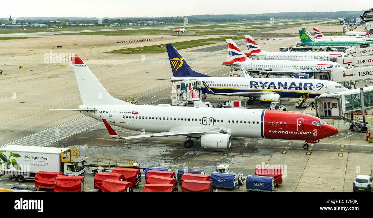 Der Flughafen London Gatwick, ENGLAND - April 2019: Boeing 737 von Norwegischen und andere Jets bis am Flughafen London Gatwick gesäumt betrieben Stockfoto