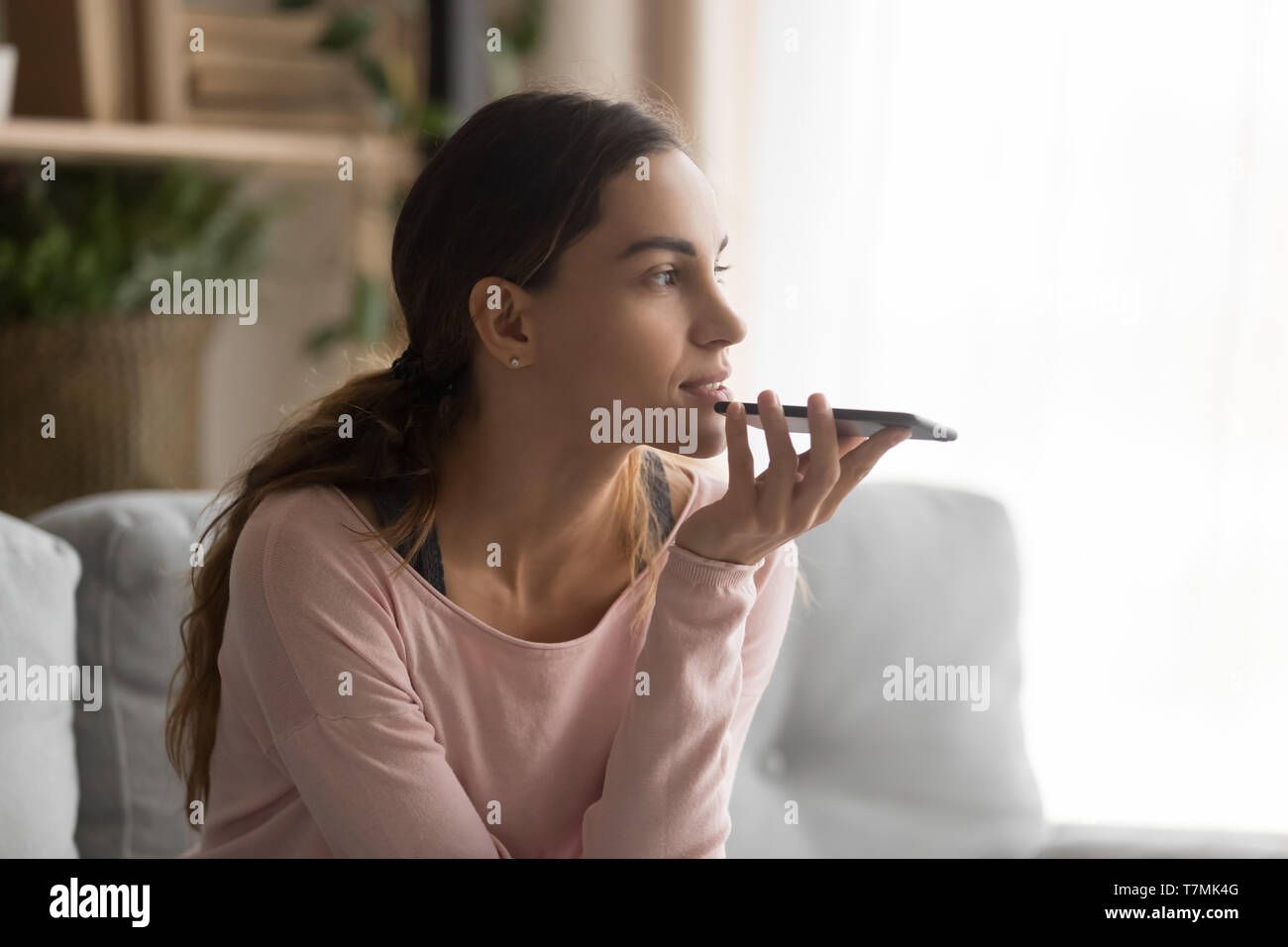 Frau mit Smartphone mithilfe virtueller Assistent oder sprechen Sie über die Freisprechanlage Stockfoto