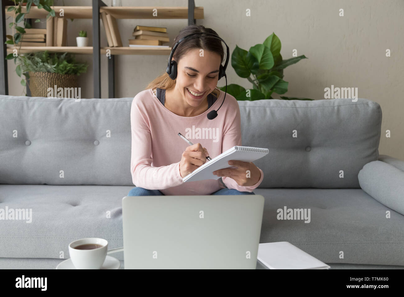 Glückliche Frau das Headset Englisch lernen mit Lehrer online Stockfoto