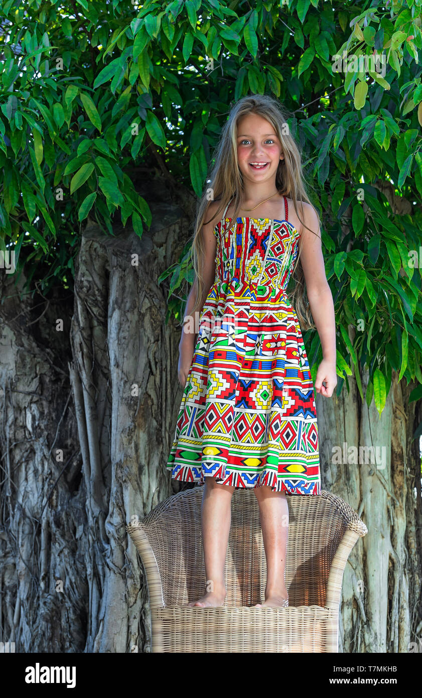 Wenig schöne Mädchen an tropischen Baum Hintergrund. Portrait von niedlichen Kind bereit für den Urlaub in den Tropen. Stockfoto