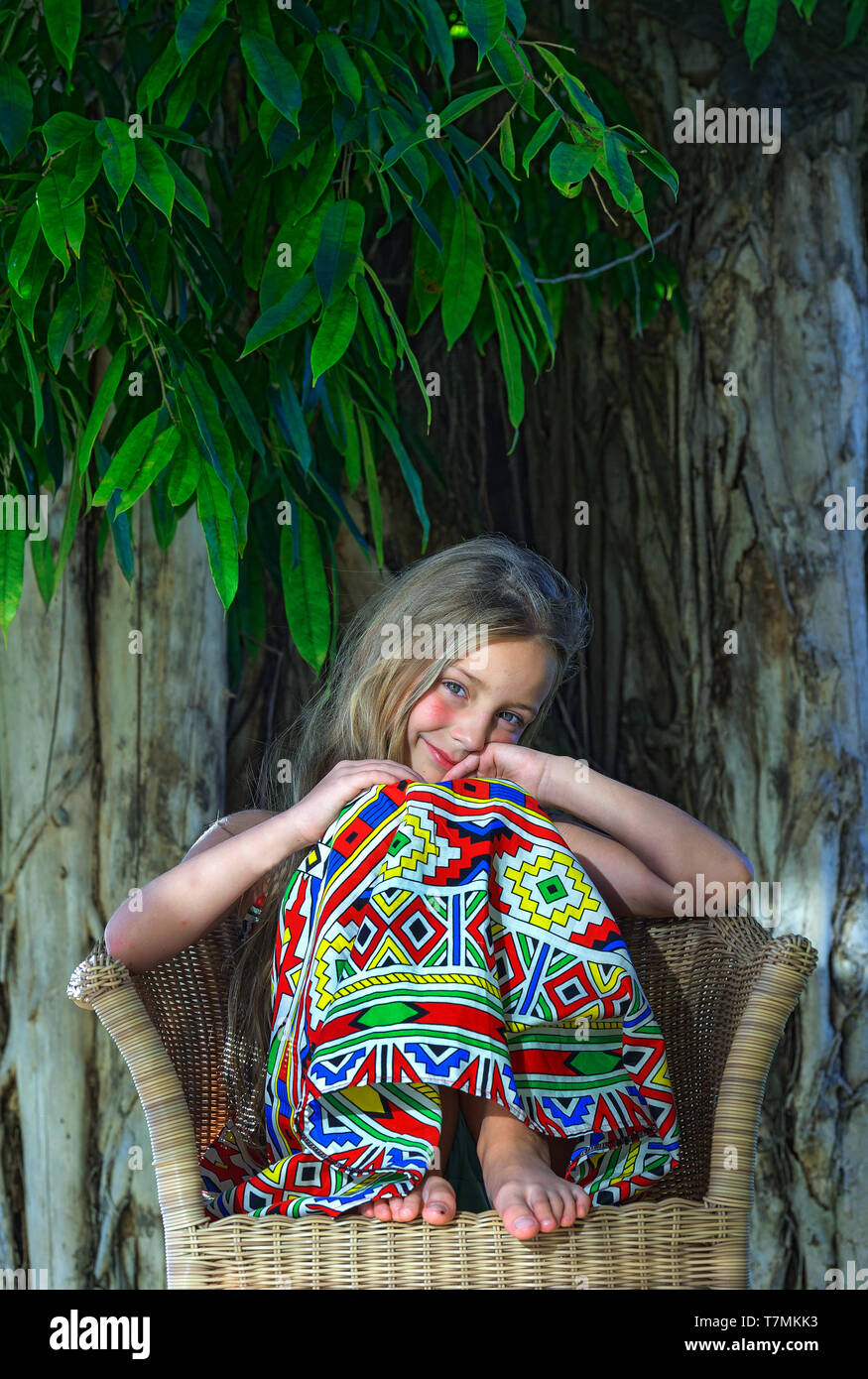 Wenig schöne Mädchen an tropischen Baum Hintergrund. Portrait von niedlichen Kind bereit für den Urlaub in den Tropen. Stockfoto