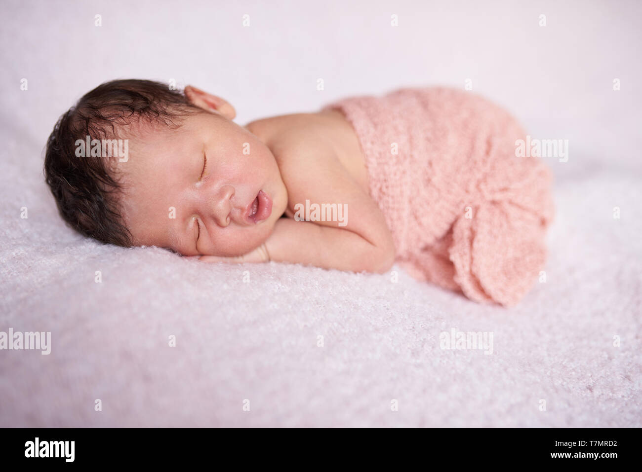 Eine niedliche kleine slepping Baby Mädchen auf weiche leichte Decke Hintergrund Stockfoto