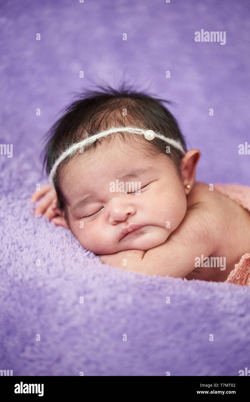 Hispanic neugeborenes Mädchen Nahaufnahme Porträt auf weichen lila Decke Stockfoto