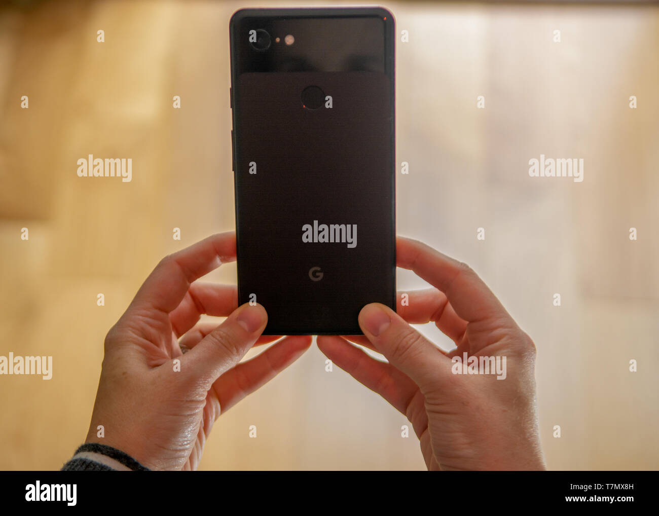 Eine Nahaufnahme von einer Frau mit einem Handy vor einem Hintergrund. Stockfoto
