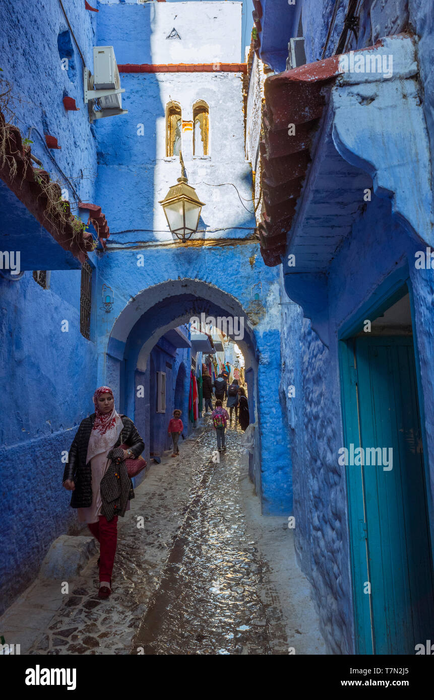 Chefchaouen, Marokko: eine marokkanische Frau geht unter einem Bogen im Blau getünchte Medina, Altstadt. Stockfoto